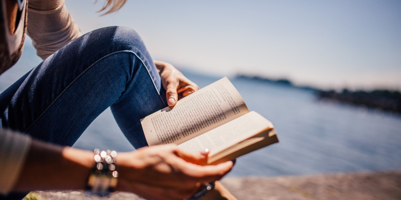 Frau am Wasser mit Buch